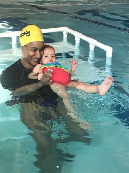 Brigette Tucker, Instructor, teaching young girl how to kick in the pool