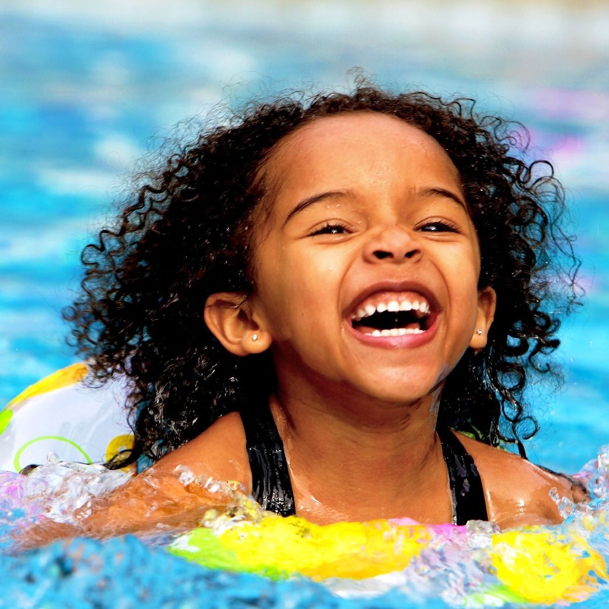smiling-young-girl-swimming-in-pool-with-floatie