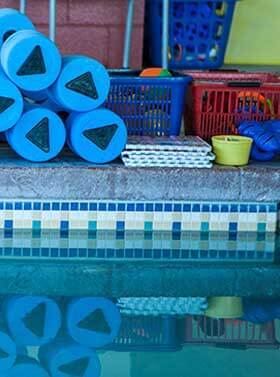 Swimming Lesson tools stacked near swimming pool